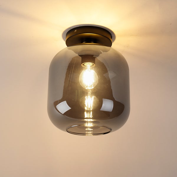 Deckenleuchte mit Schirm aus Rauchglas und dunkler Metallhalterung, inklusive leuchtendem Leuchtmittel.