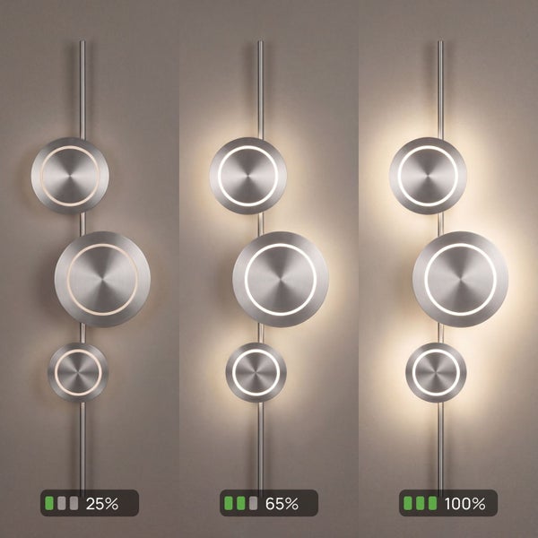 Moderne LED-Wandleuchte aus gebürstetem Metall mit drei runden Leuchtelementen in drei Dimmstufen: 25 Prozent, 65 Prozent und 100 Prozent.