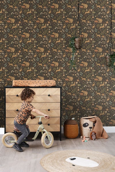 Kinderzimmer mit gemusterter Tapete, Kommode und Kind auf einem Laufrad