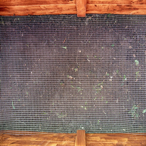 Drahtgeflecht über Erdboden und Holzeinfassung