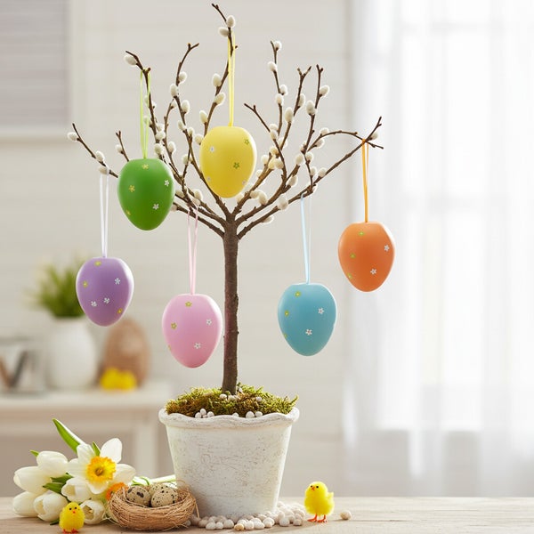 Weidenzweig in einem Topf dekoriert mit bunten Ostereiern als Osterdekoration auf einem Tisch mit Osterdeko Elementen