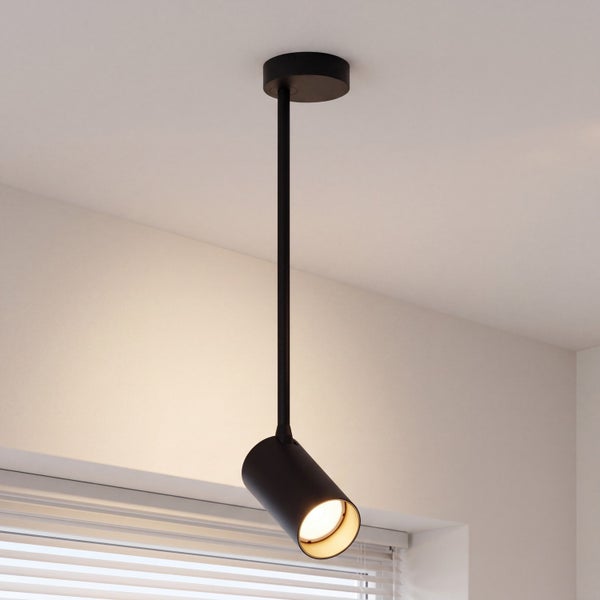 Moderne, minimalistische Deckenleuchte als Spot in Schwarz, mit einer Stange montiert, strahlt warmes Licht aus.
