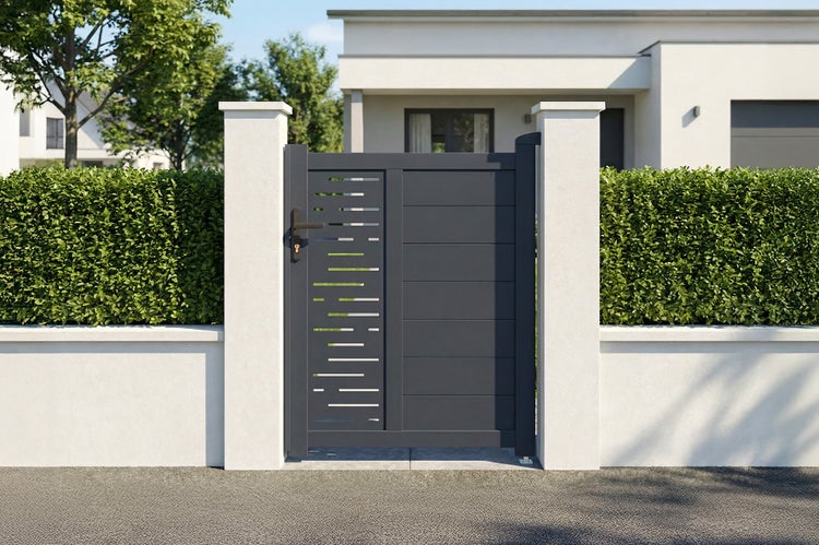 Modernes Gartentor aus anthrazitfarbenem Aluminium mit Lamellen und Lochmuster, montiert zwischen weißen Pfeilern vor einer Hecke und einem Haus.
