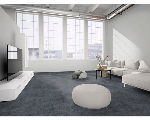 Modernes, helles Wohnzimmer mit dunklem Boden in Steinoptik, weißem Sofa, flachem TV-Board und großen Fenstern.