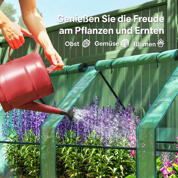 Person gießt mit einer Gießkanne blühende Pflanzen in einem Folien-Gewächshaus mit aufrollbaren Seitenwänden für Obst, Gemüse und Blumen.