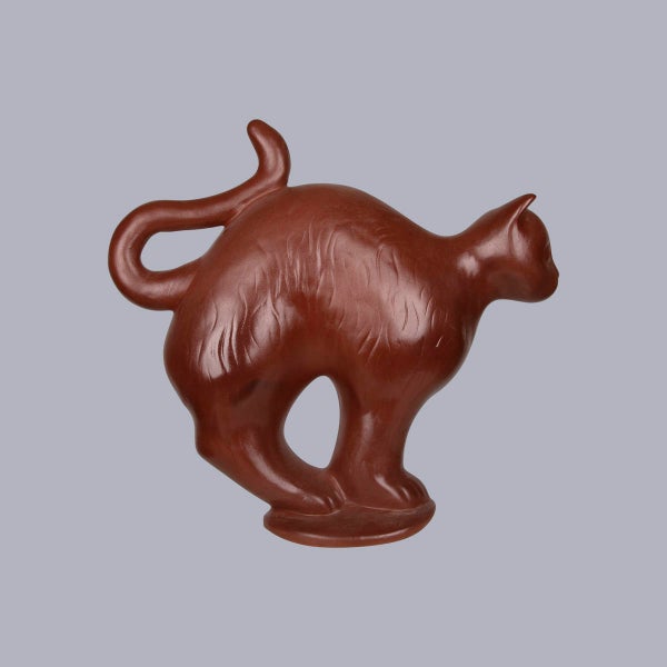 Braune Katzenfigur aus Keramik mit strukturierter Oberfläche, gewölbtem Rücken und aufgestelltem Schwanz.