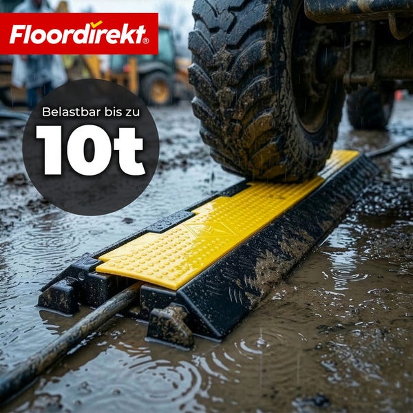 Floordirekt Logo. Eine robuste Kabelbrücke auf einer Baustelle, über die ein Reifen fährt. Die Traglast beträgt bis zu 10 Tonnen.