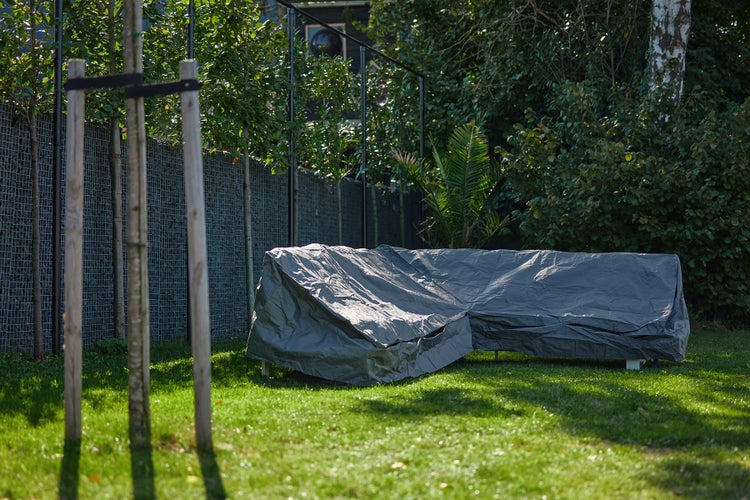 Gartenmöbel mit Schutzhülle auf Rasenfläche