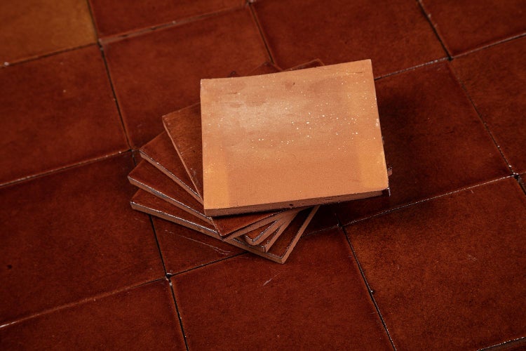 Stapel Terrakottafliesen auf verlegten Terrakottafliesen