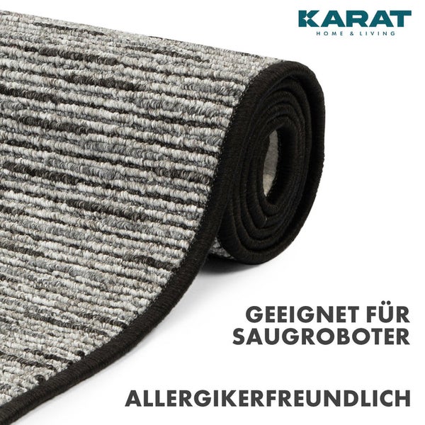 Eingerollter Teppich mit Streifenstruktur, Karat Home and Living Logo, geeignet für Saugroboter und allergikerfreundlich.