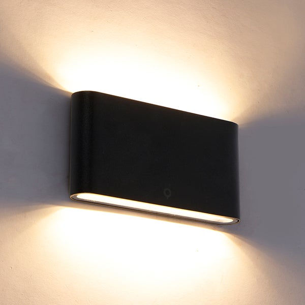 Schwarze, rechteckige LED-Wandleuchte mit Up-and-Down-Lichteffekt an einer Wand montiert.