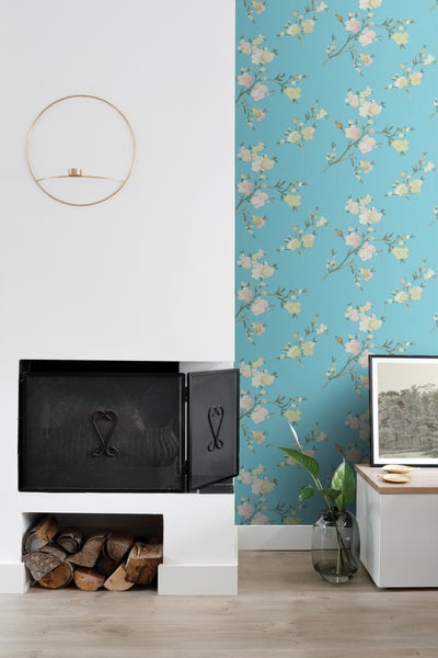Innenraum mit Kamin, Brennholz, Wanddekoration und Blumenmuster-Tapete