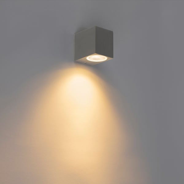 Würfelförmige Wandleuchte mit nach unten gerichtetem Lichtkegel.
