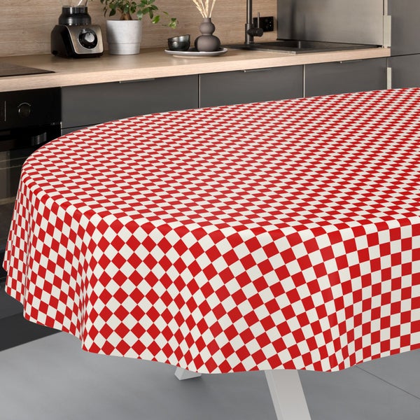Ovale Tischdecke mit rot-weißem Karomuster in einer modernen Küche mit grauen Schränken und heller Arbeitsplatte.