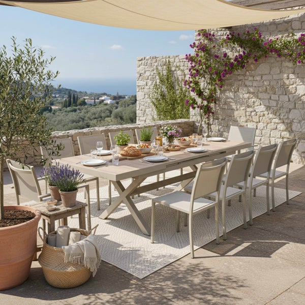Moderne Garten-Essgruppe auf einer Steinterrasse mit großem Tisch, Stühlen, Sonnensegel und Blick auf die Landschaft.