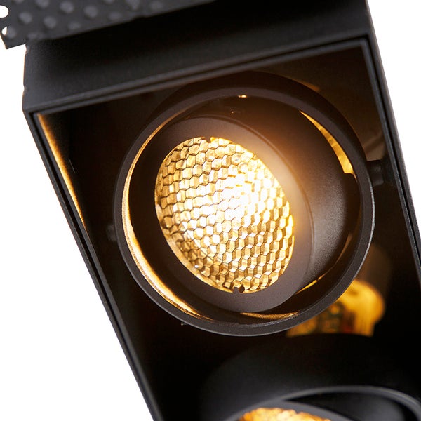 Detailansicht eines schwarzen LED-Strahlers mit eingeschaltetem Leuchtmittel und Wabengitter-Diffusor.