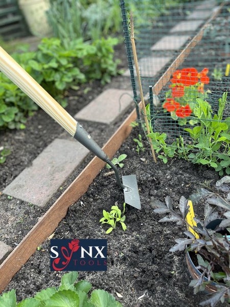 Gartenhacke im Einsatz in einem Gartenbeet.