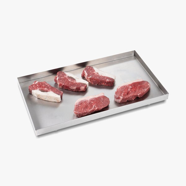 Fünf rohe Rindfleischsteaks auf einem Metalltablett.