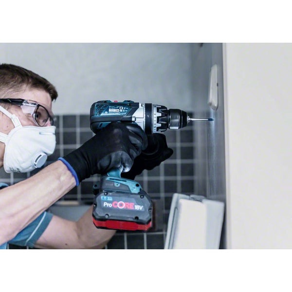 Handwerker bohrt mit einer Bohrmaschine ein Loch in die Wand.