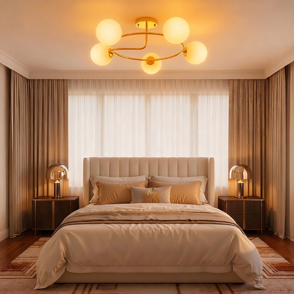 Modernes, helles Schlafzimmer mit Doppelbett, gepolstertem Kopfteil, zwei Nachttischen mit goldenen Lampen und einer großen Deckenleuchte.