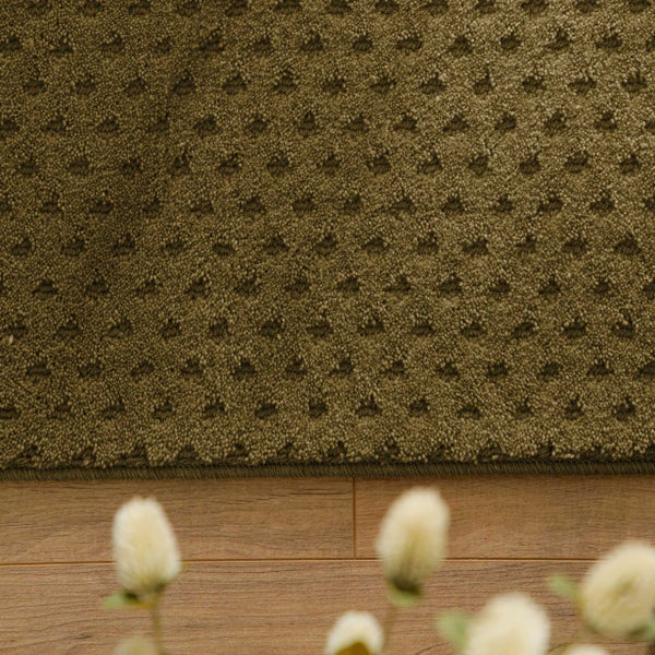 Kurzflor-Teppich mit strukturiertem Punktmuster auf hellem Holzboden.