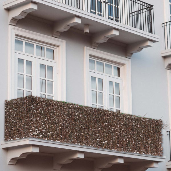 Fassadenansicht mit Balkon und dekorativem Sichtschutz aus Blättern