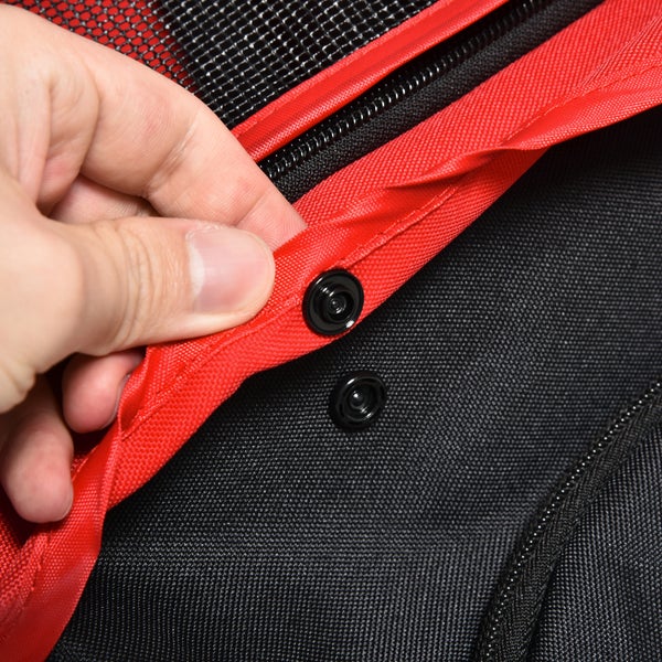 Detailansicht einer Tasche mit Druckknopfverschluss, Reißverschluss und Netzgewebe, Hand öffnet den Verschluss.
