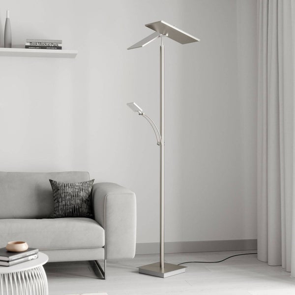 Moderne Stehleuchte mit verstellbarem Deckenfluter und Lesearm in einem hellen Wohnzimmer neben einem Sofa.