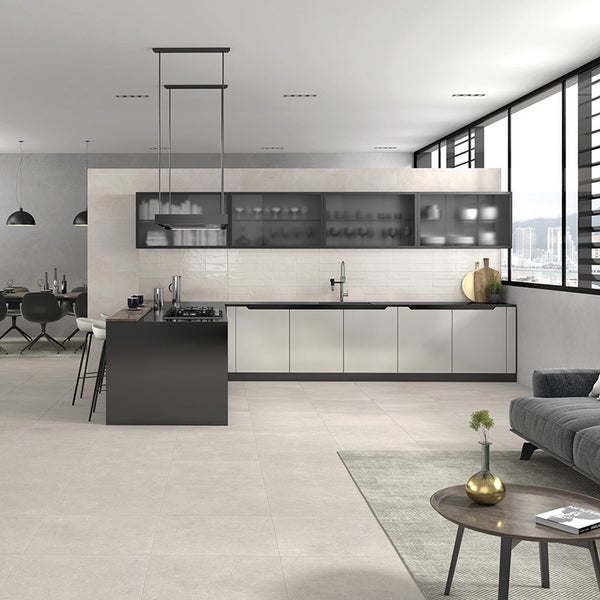Moderne offene Wohnküche mit Kochinsel, dunklen Hängeschränken und hellem Fliesenboden in einem weitläufigen, minimalistischen Wohnraum.