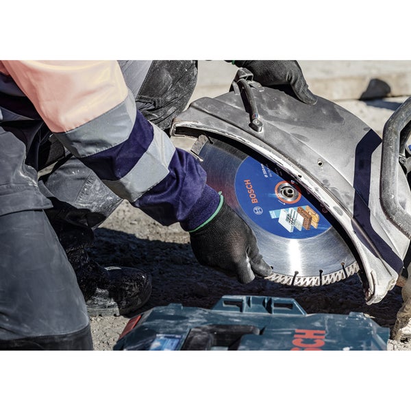 Eine Person legt eine Bosch Diamanttrennscheibe in eine Steintrennmaschine ein.