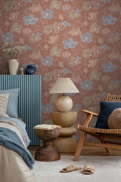 Wohnzimmer mit Vliestapete mit Blumenmuster vor der Wand, stilvoll eingerichtet mit modernen Möbeln und Dekorationsobjekten.