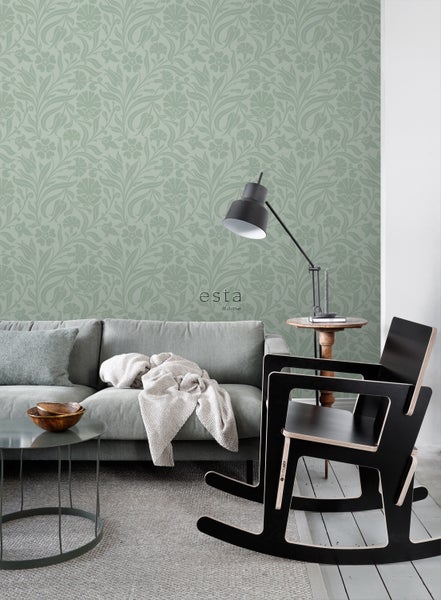 Wohnzimmer mit grauer Couch, Tisch und gemusterter Tapete