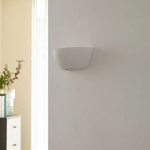 Halbrunde Wandleuchte aus Gips montiert an einer Wand in einem hellen Innenraum.