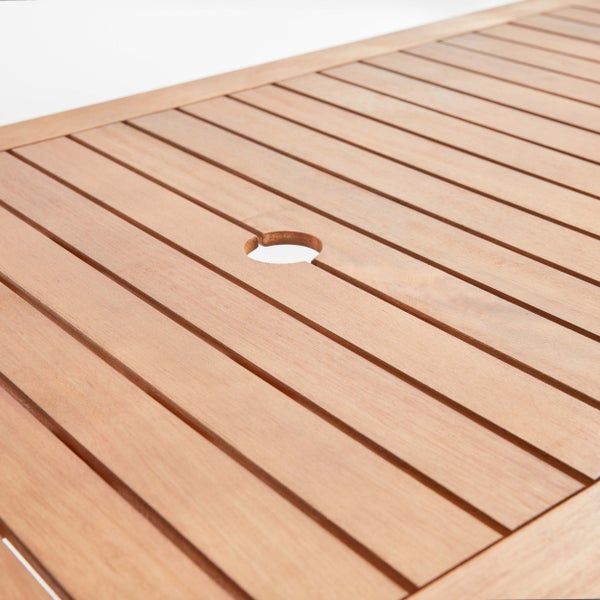Detailansicht einer Tischplatte aus Holzlatten mit einer Öffnung für einen Sonnenschirm.