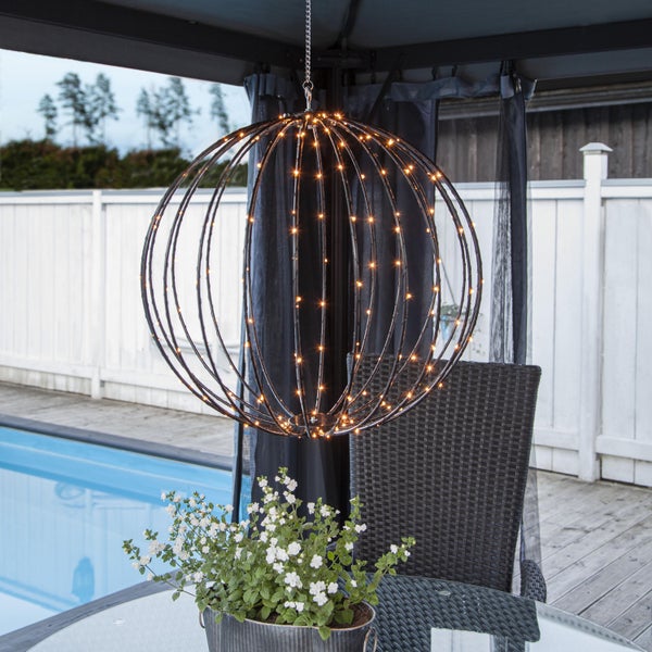 Dekorative Gartenbeleuchtung mit drei LED-Kugeln über einem Gartentisch