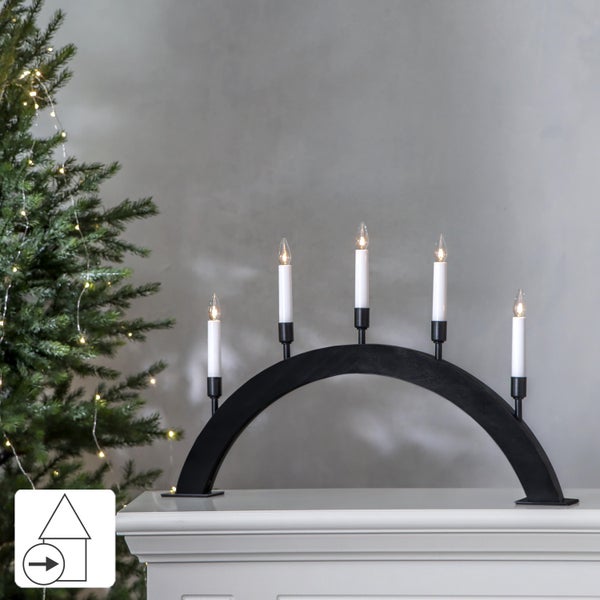 Schwarzer Lichterbogen mit fünf elektrischen Kerzen auf einem Kaminsims