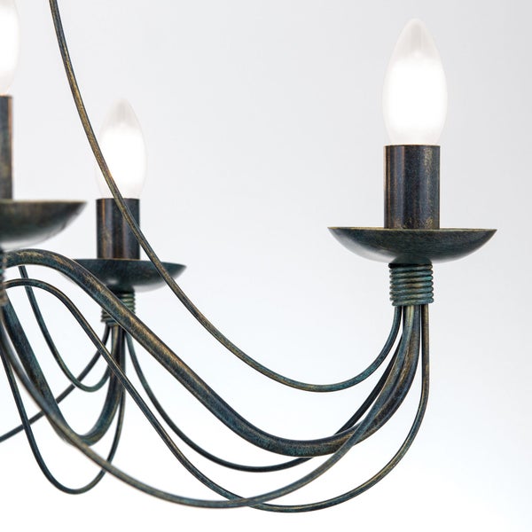 Detailansicht eines Kronleuchters aus Metall mit geschwungenen Armen und Kerzenfassungen im rustikalen Design