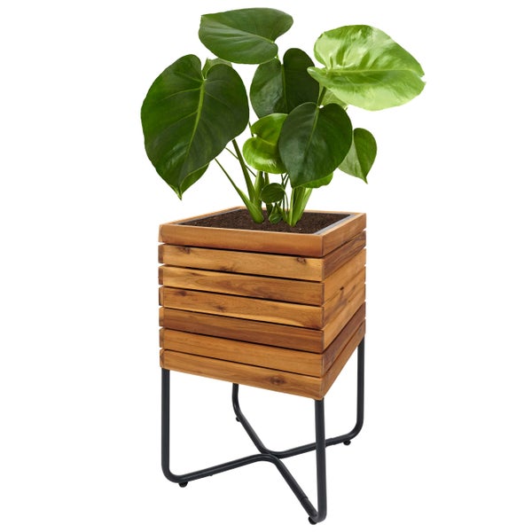 Pflanzkübel aus Holzlamellen auf einem schwarzen Metallgestell mit einer Monstera-Pflanze.