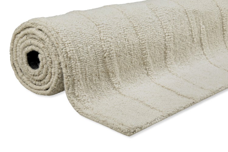Aufgerollter, strukturierter Teppich in Beige mit dezentem Streifenmuster.