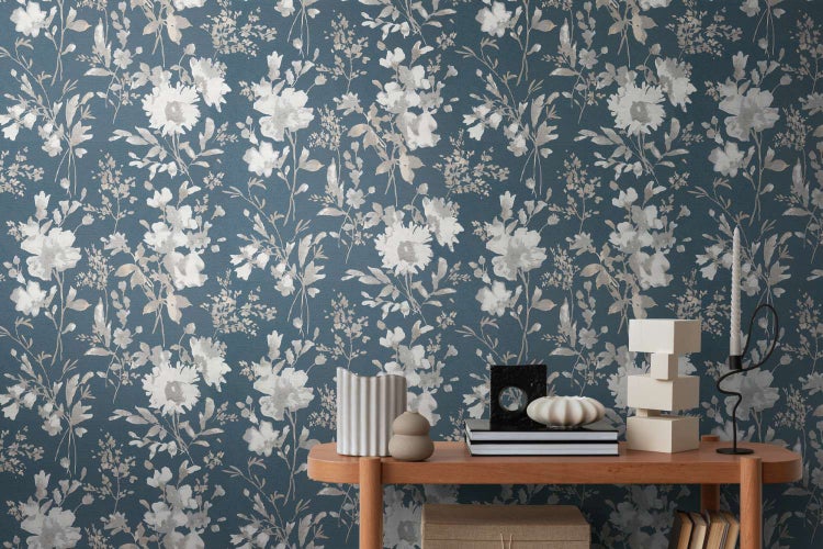 Vliestapete mit floralem Blumenmuster an einer Wohnzimmerwand, kombiniert mit einer Konsole mit Dekorationsobjekten.