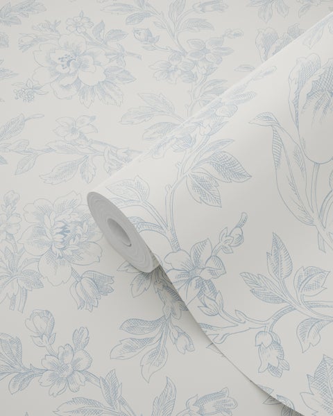 Vliestapete mit klassischem Blumenmuster, skizzierte blaue Blüten und Blätter auf hellem Grund.