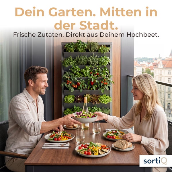 Ein Paar genießt eine Mahlzeit auf einem Stadtbalkon mit vertikalem Pflanzsystem für Kräuter und Gemüse an der Wand.