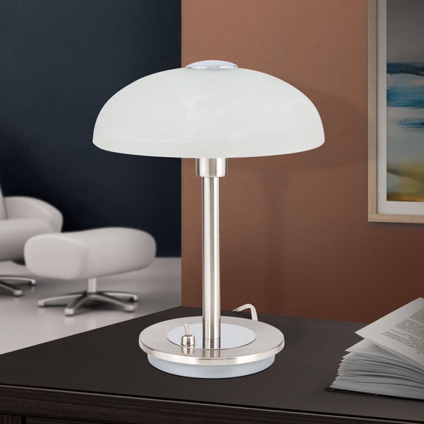 Tischleuchte mit Glasschirm auf einem Tisch