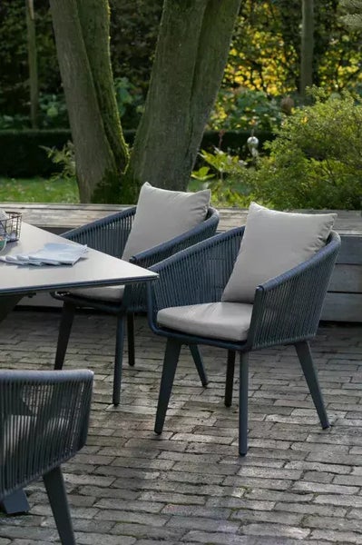 Szene im Freien mit Gartentisch und Sesseln mit Kissen