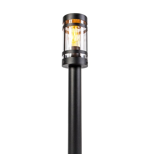 Schwarze Wegeleuchte für den Außenbereich mit zylindrischem Glasschirm und sichtbarem Leuchtmittel im Vintage-Stil.