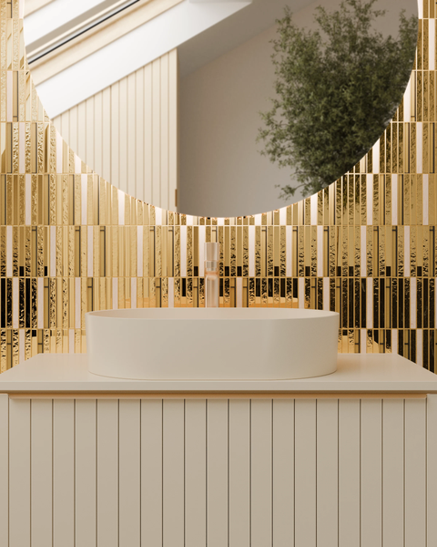 Modernes Badezimmer mit rundem Spiegel, goldfarbenen Mosaikfliesen, einem weißen Aufsatzwaschbecken auf einem Unterschrank mit vertikalen Lamellen.