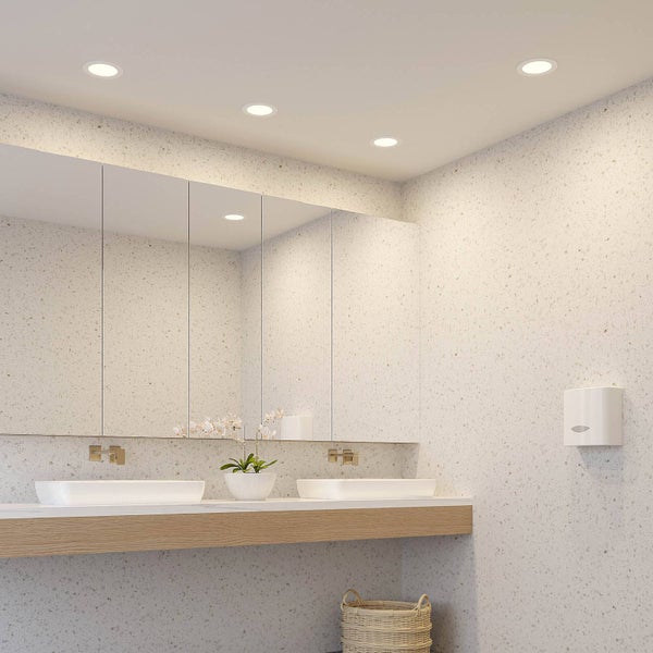 Helles Badezimmer mit mehreren runden LED-Einbaustrahlern an der Decke, einem großen Wandspiegel und zwei Waschbecken auf einem Holzregal.
