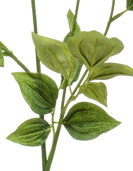 Künstliche Pflanze Yucca im schwarzen Topf, Detailansicht von Stamm und langen grünen Blättern.