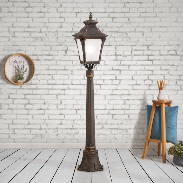 Klassische Außenleuchte als Standlampe in Antik-Optik vor einer weißen Backsteinwand in einem hellen Raum mit Dielenboden.