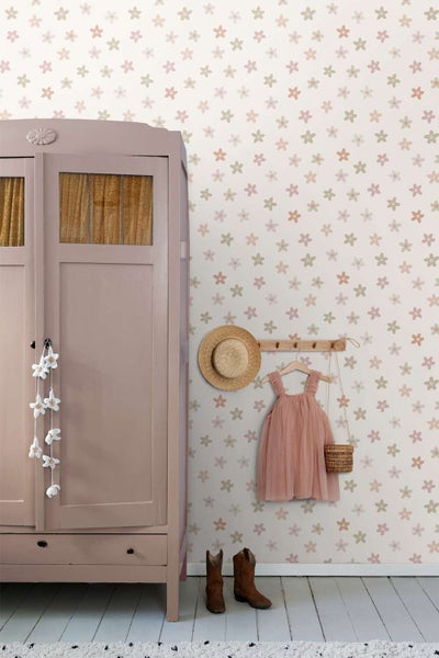 Vliestapete mit Blumenmuster in einem Kinderzimmer mit einem Holzschrank und Kinderkleidung an einer Garderobenleiste